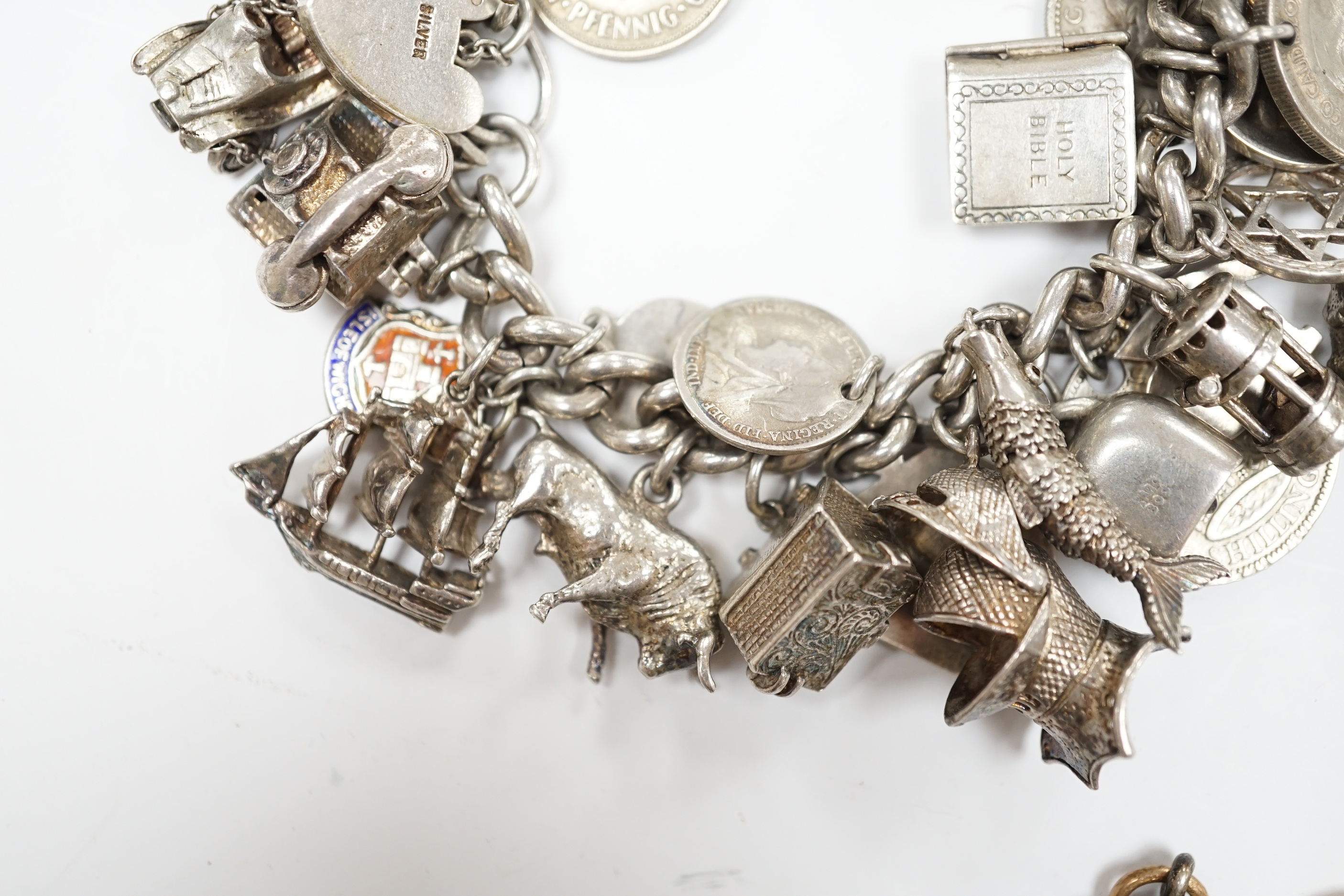 A silver charm bracelet, hung with assorted mainly white metal charms including tankard and Knight's helmet, two 'melted' ingots and a silver medallion.